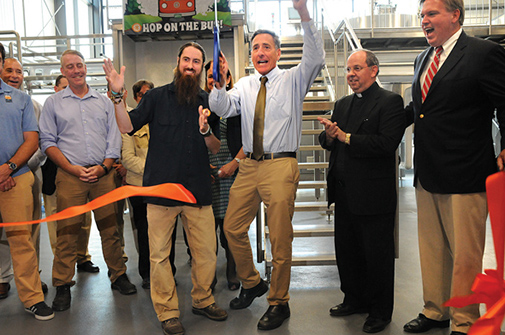 OTTER CREEK BREWING President and CEO Dan Fulham, right, stands with St. Mary’s Church Pastor Father William R. Beaudin as Gov. Peter Shumlin and Otter Creek Brewmaster Mike Gerhart cut the ribbon on the Middlebury company’s new 8,000-square-foot brewhouse expansion last Thursday morning. Below, Fulham addresses a crowd. Independent photos/Trent Campbell